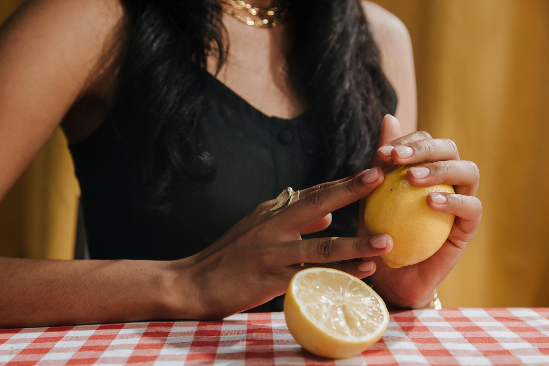 Eine Frau hält eine frische Zitrone in der Hand und lächelt, symbolisierend Frische und Vitalität während der Menopause