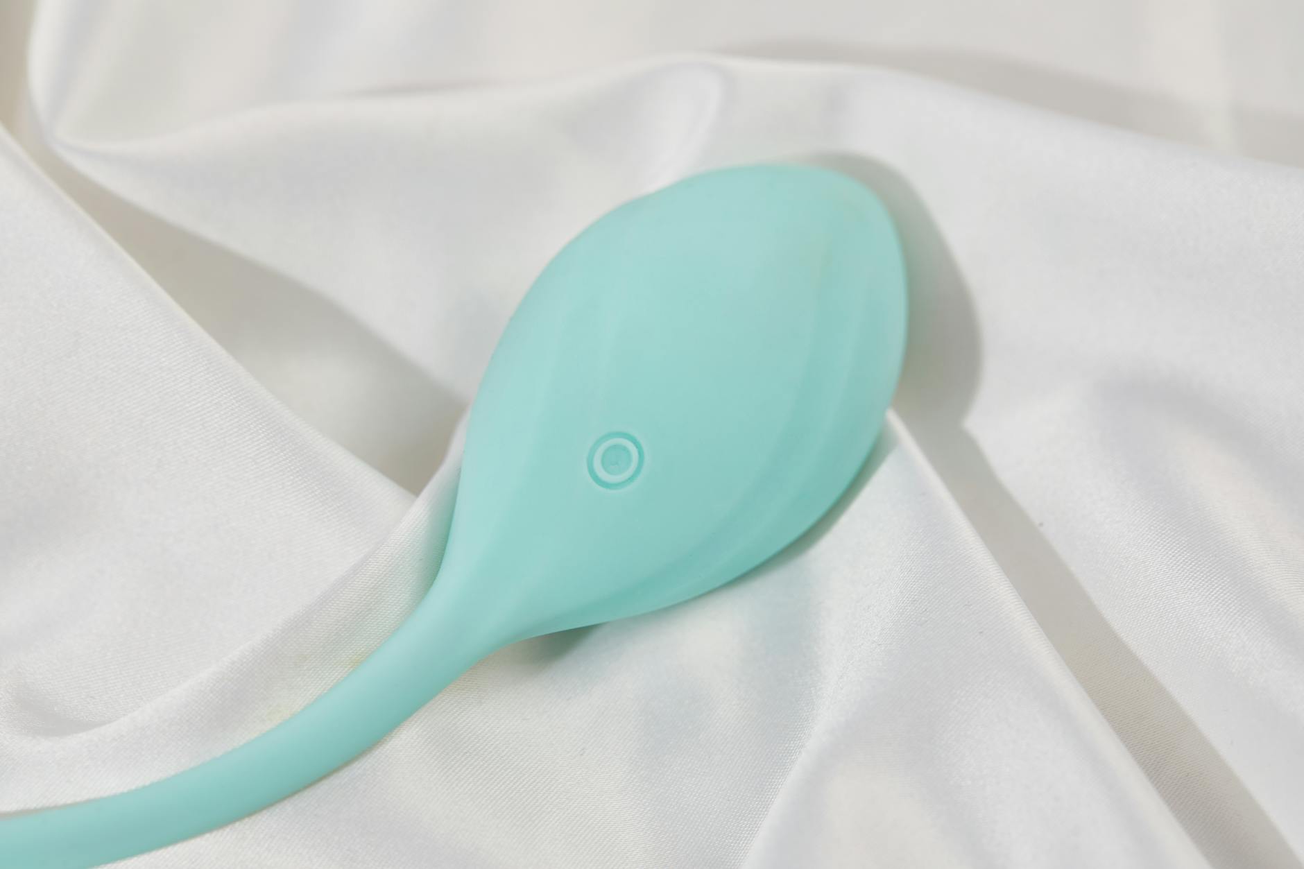 Woman holding a blue and pink vibrator, exploring pleasure options thoughtfully