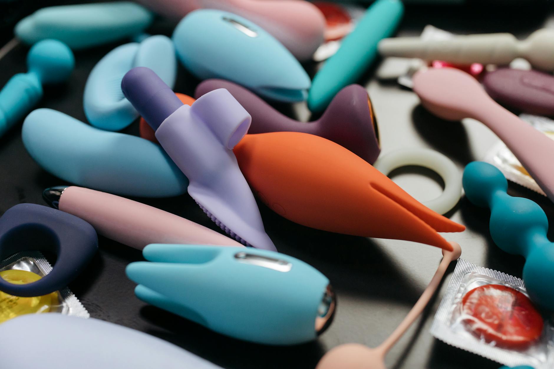 Close-up of hands holding a sleek vibrator against a purple background