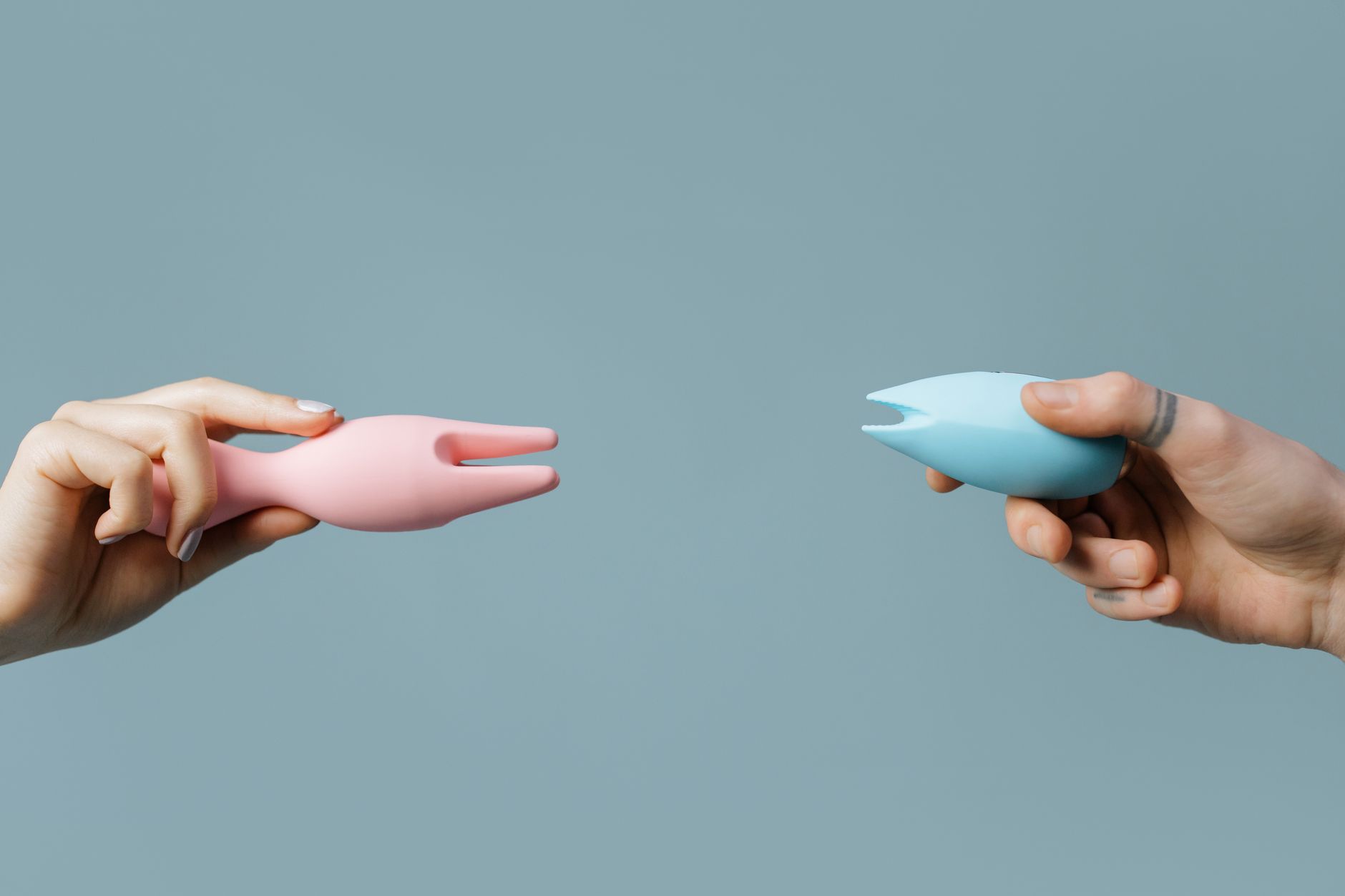 Close-up of hands holding a sleek lemon clitoral vibrator against a purple background, symbolizing reconnection and intimate pleasure.
