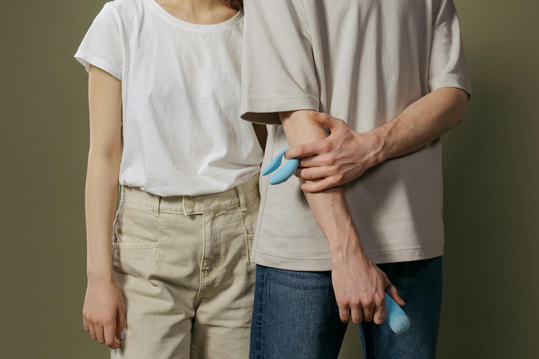 Woman holding multiple silicone clitoral vibrators, contemplating which tool fits her body