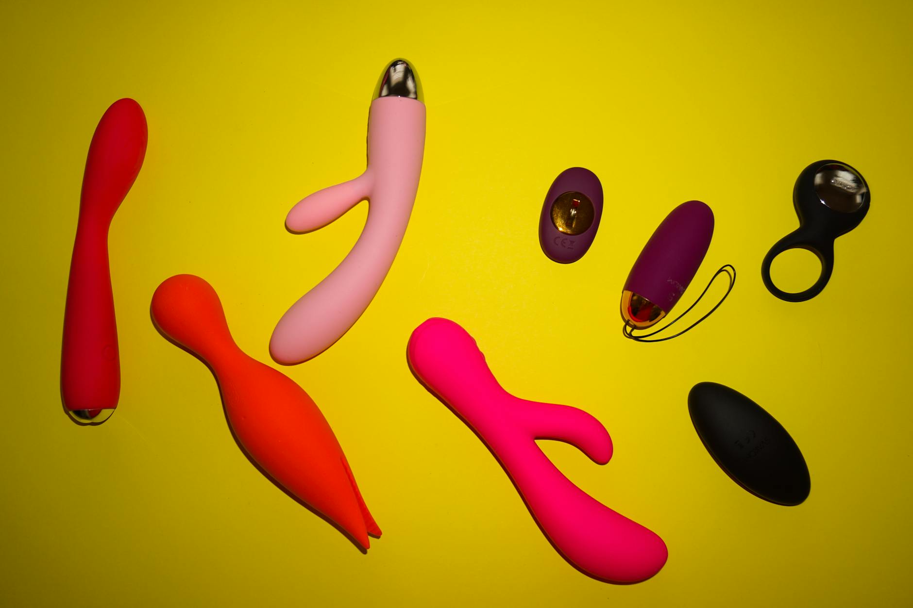 Vibrant arrangement of colorful vibrators on a bright yellow surface