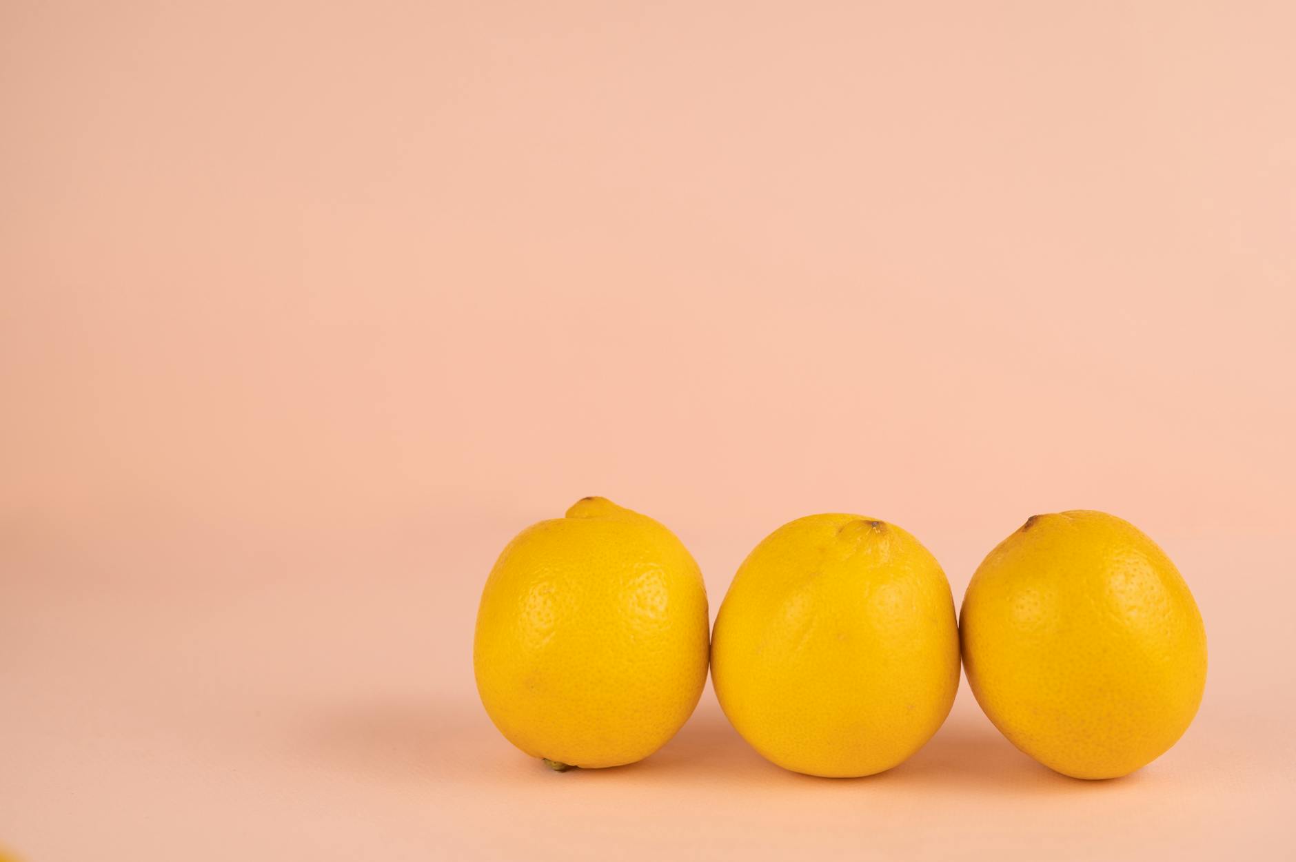 Person holding two colorful lemon vibrators against a purple background