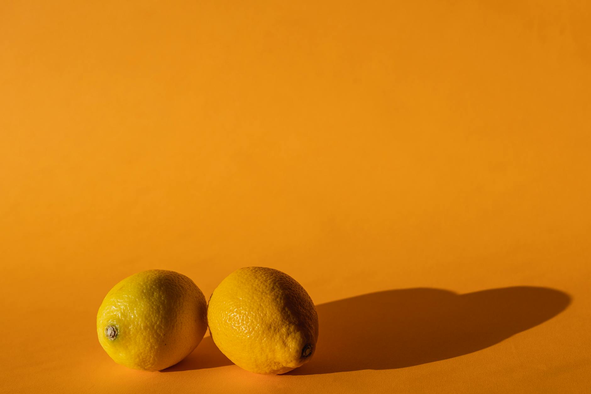 Fresh lemons on a bright yellow background, symbolizing clarity and renewal during relationship challenges